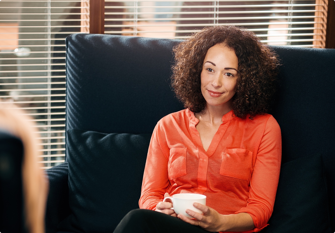 A female therapist sitting in a chair listening to her patient.