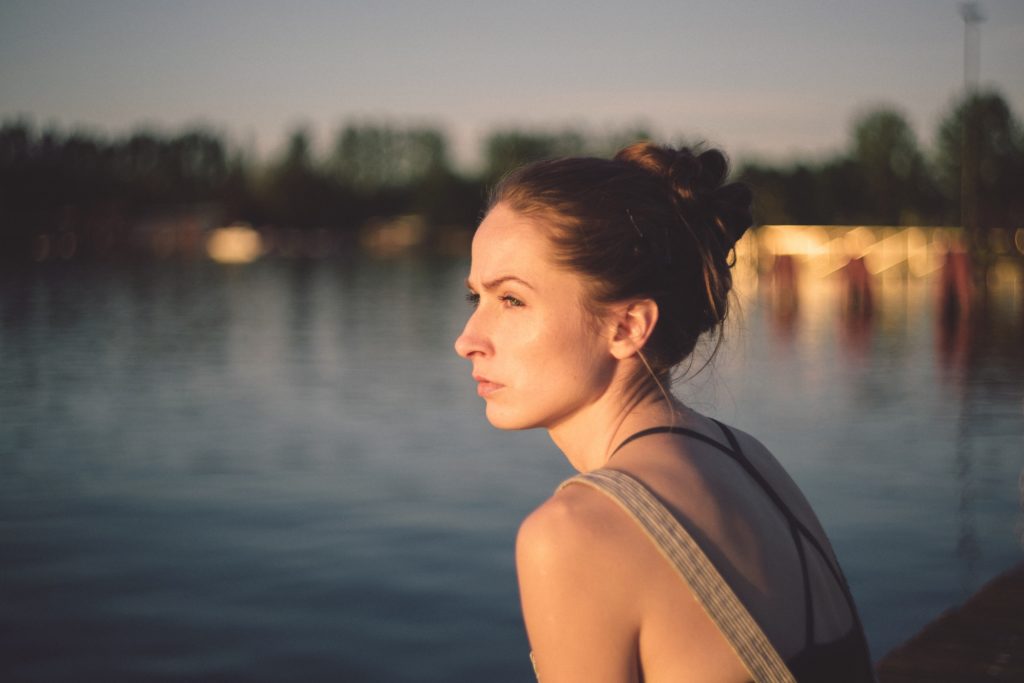 Woman looking out at water to show comparative suffering