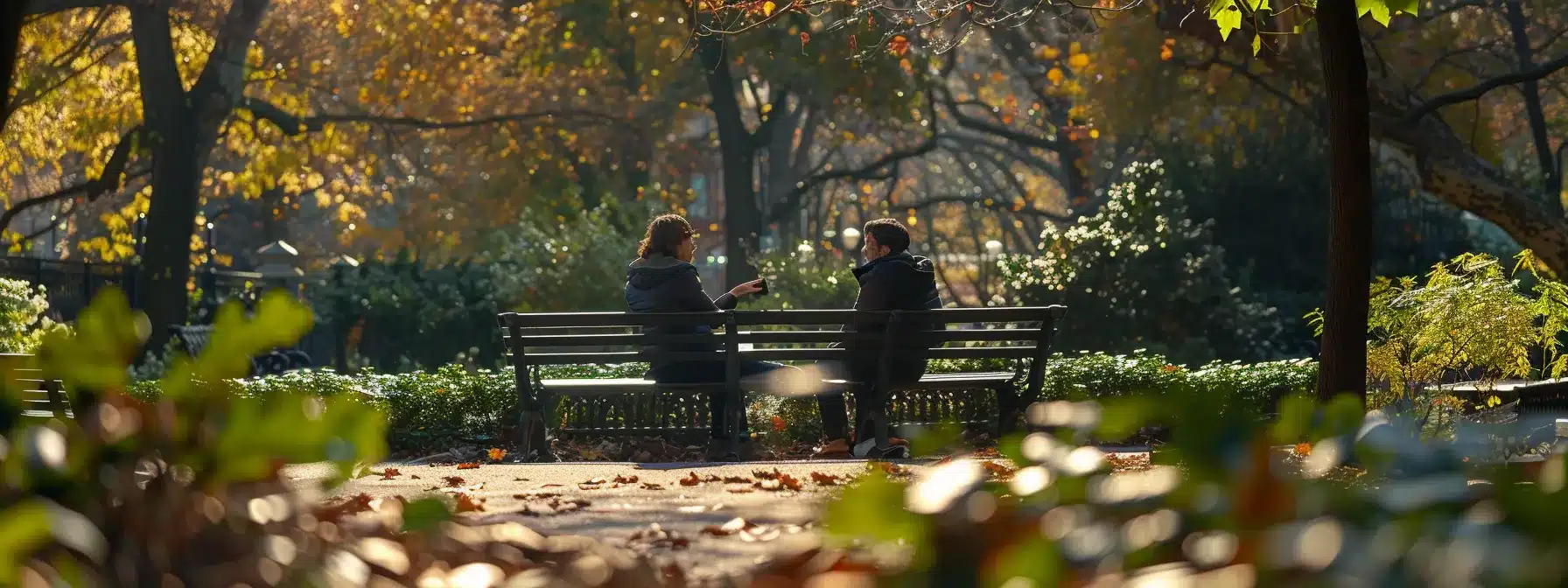 two people having a deep conversation while sitting on a park bench.