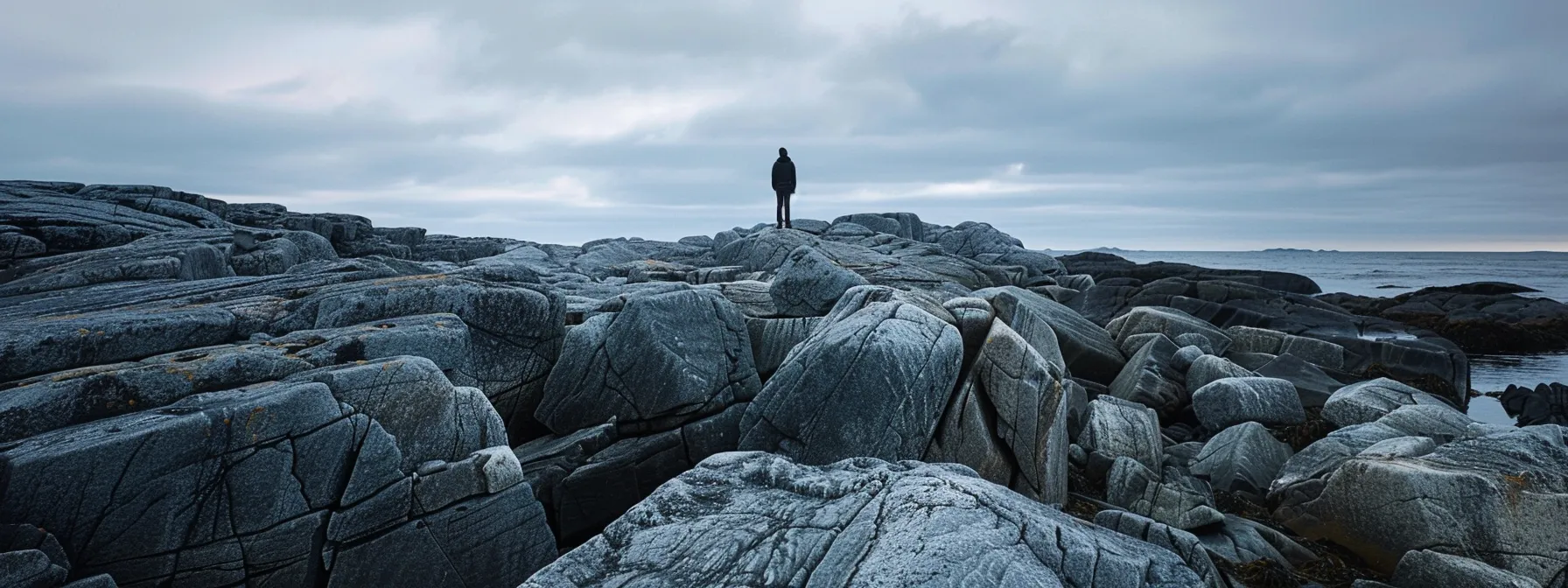 a person standing calmly on a rocky shore, blending seamlessly with the neutral gray rocks around them, symbolizing effective boundary setting with the gray rock method.