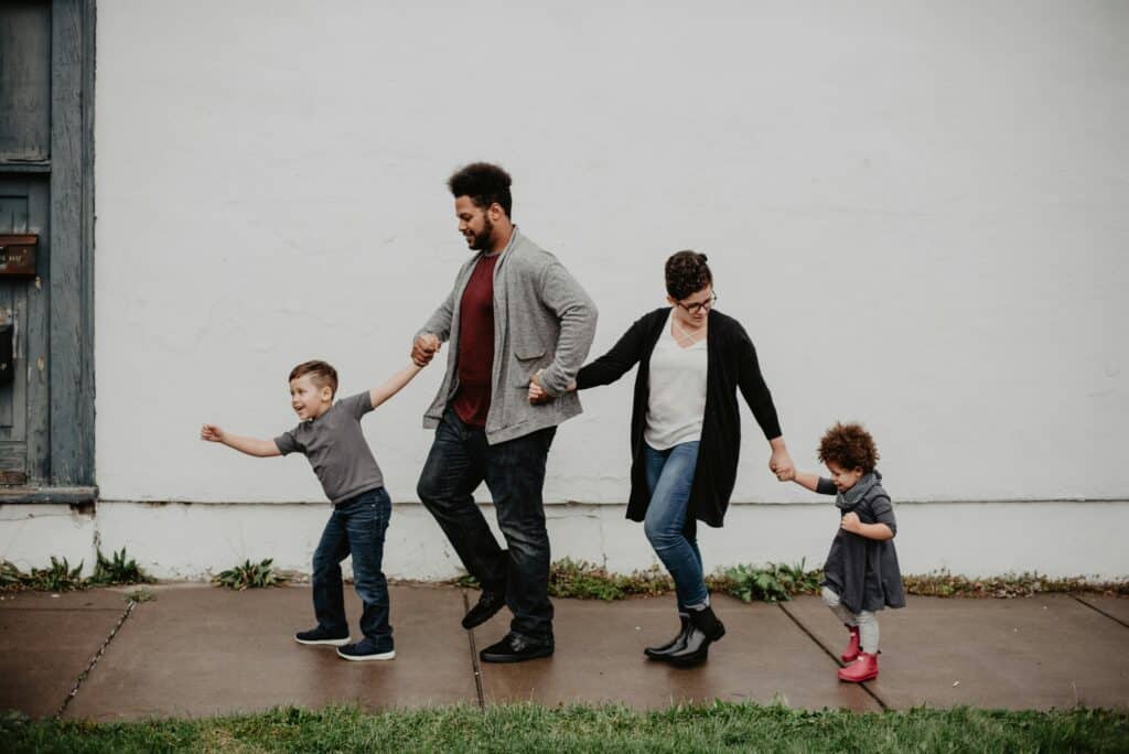 Family holding hands walking on the sidewalk