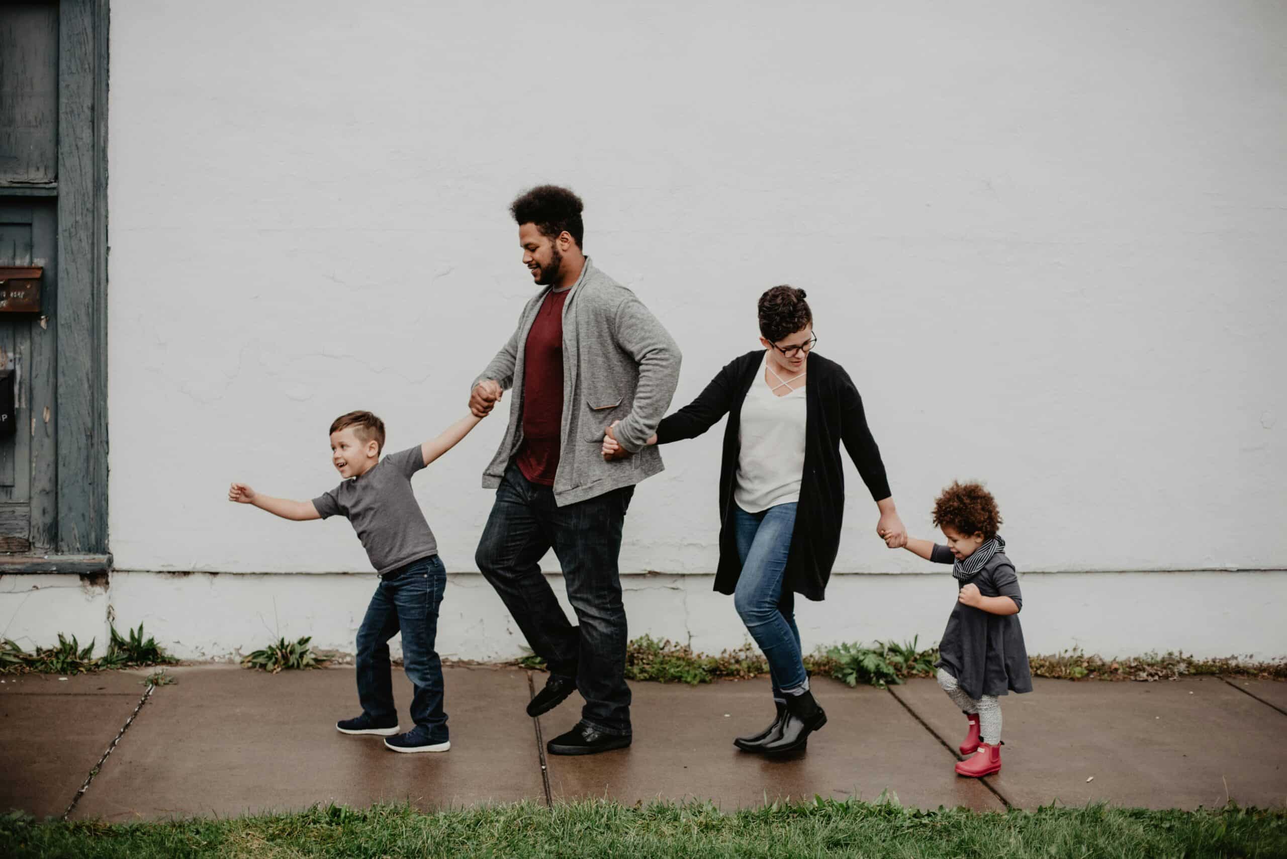 Family holding hands walking on the sidewalk